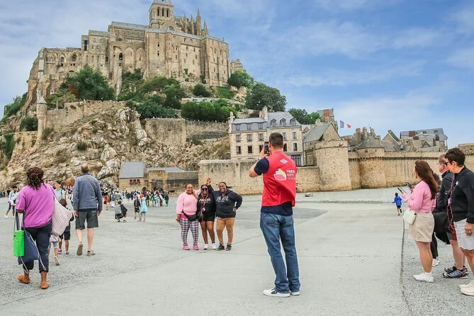 People walking along the bridge toward the Mont