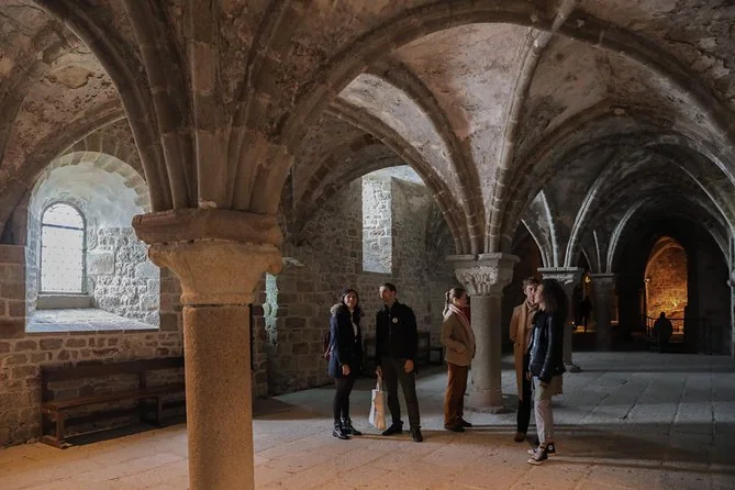 Visitors in a vaulted Gothic hall inside the abbey